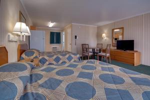 a hotel room with a large bed and a table at Sahara Motel in Ocean City