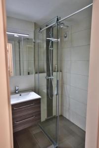 een badkamer met een glazen douche en een wastafel bij Weiherhof in Wildhaus