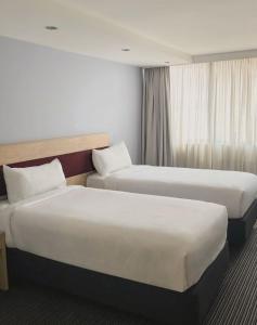 a hotel room with two beds and a window at Central Studio Hotel Sydney in Sydney