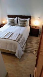 a bedroom with a large bed with white sheets and pillows at Apartamento El Castillo in La Adrada