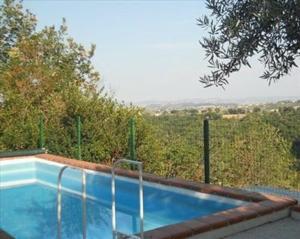 una piscina con vistas a algunos árboles en Appartement in Catignano mit Whirlpool, Garten und Terrasse, en Catignano