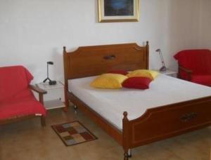1 dormitorio con 1 cama con almohadas amarillas y rojas en Appartement in Catignano mit Whirlpool, Garten und Terrasse, en Catignano