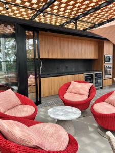 アウト・パライーゾ・デ・ゴイアスにあるPousada Flor de Anisのリビングルーム(赤い椅子、テーブル付)