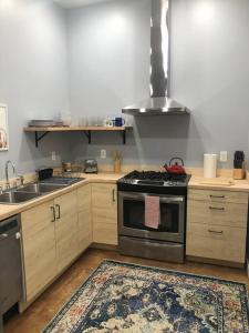 a kitchen with a stove and a sink with a rug at Yellowstone Hideaway in Livingston