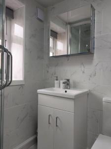 Baño blanco con lavabo y espejo en Dream Ensuite Rooms en Birmingham