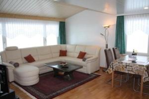 sala de estar con sofá blanco y mesa en Casa Uccello, en Wildhaus