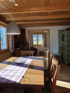 une salle à manger avec une table en bois et une cuisine dans l'établissement Neuer Sigerst, Haus, à Wildhaus
