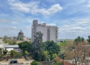 un edificio alto y blanco en medio de una ciudad en Monoambiente luminoso céntrico con cochera en San Nicolás de los Arroyos