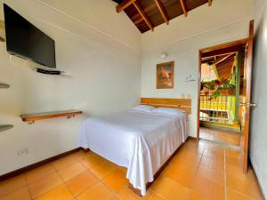 een slaapkamer met een bed en een flatscreen-tv bij HOTEL MONTE VERDE in Concordia