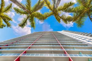 a tall building with palm trees in front of it at BeachWalk Resort #2902 - WATERFRONT RESORT HOME with DIRECT OCEAN VIEW in Hallandale Beach
