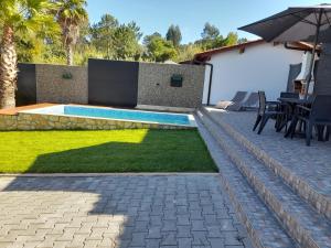 a backyard with a swimming pool and a table and chairs at Leiria Village casa zen in Leiria
