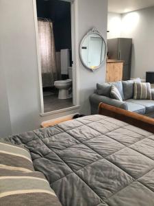 1 dormitorio con cama, sofá y espejo en Downtown Yellowstone Bungalow en Livingston