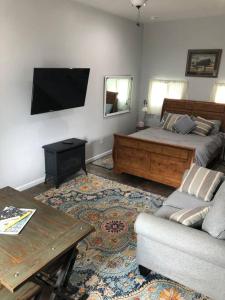 a bedroom with a bed and a couch and a tv at Downtown Yellowstone Bungalow in Livingston