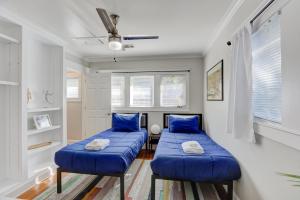 two beds in a room with blue pillows at Hip and Spacious Midtown Cottage near Beale Street in Memphis
