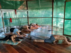een groep mensen die yoga doen op de vloer bij Amaca Eco Station in Iquitos
