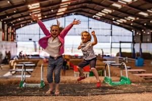 zwei kleine Kinder springen auf einem Spielplatz in der Unterkunft Beau - Brambles Chine, Colwell Bay - 5 star WiFi - Short walk to The Hut and beach - 1 night stays available - Ferry offers in Freshwater