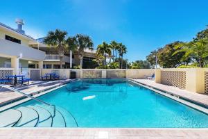 a swimming pool with blue chairs and a building at Your stay on the Bay! in Ruskin