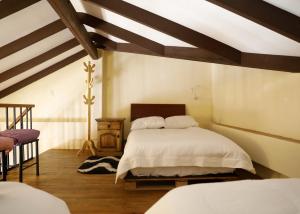 a bedroom with two beds and a wooden ceiling at Olala house in Sucre