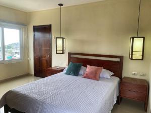 a bedroom with a bed with three pillows on it at Hotel Boutique Nazo in Manta