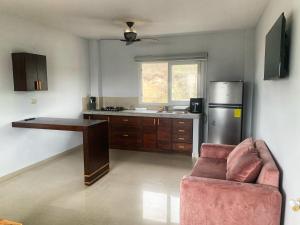 a kitchen with a couch and a table and a refrigerator at Hotel Boutique Nazo in Manta