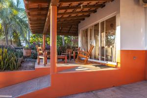 um alpendre de uma casa com uma mesa e cadeiras em Casa Belen - Beautiful Beach View Home on Stone Island em Isla La Piedra