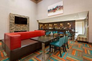 un restaurante con un sofá rojo y un bar en Best Western Bradbury Inn & Suites, en Perry