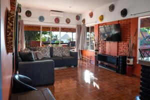 uma sala de estar com um sofá e uma televisão em Casa Belen - Beautiful Beach View Home on Stone Island em Isla La Piedra