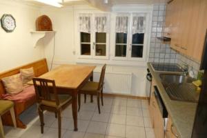 - une cuisine avec une table, des chaises et un évier dans l'établissement Haus am See - a79839, à Lungern