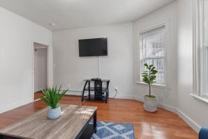 a living room with a table and a flat screen tv at Frog Hollow Red Door Retreat in Hartford