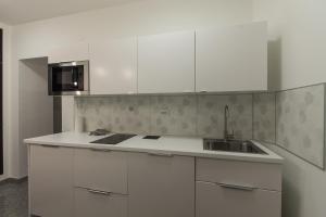- une cuisine blanche avec évier et four micro-ondes dans l'établissement Smart Apartment, à Zagreb