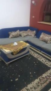 um sofá azul com uma cama numa sala de estar em Haram City em Cidade 6 de Outubro