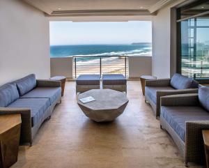 een wachtkamer met banken en een tafel en de oceaan bij Suncoast Hotel & Towers in Durban