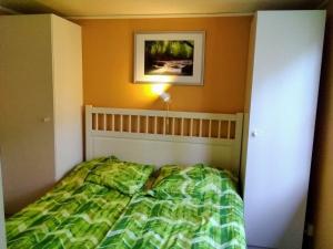 1 dormitorio con 1 cama y una foto en la pared en Gepflegtes Ferienhaus mit eigenem Saunahaus, 