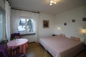 een slaapkamer met een bed, een tafel en een raam bij Casa Thuja in Ascona