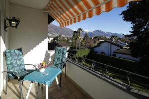 een blauwe stoel op een balkon met uitzicht bij Casa Thuja in Ascona