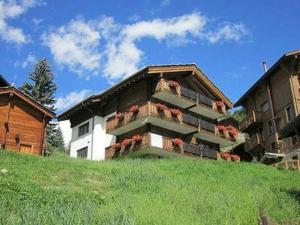 a building with flower boxes on the side of it at Aiolos Apartments 6 Personen in Zermatt