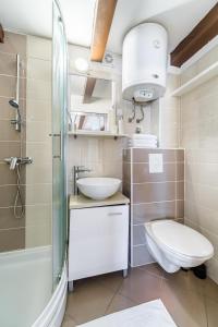 e bagno con lavandino, servizi igienici e doccia. di Sv.Duje Apartments a Spalato (Split)