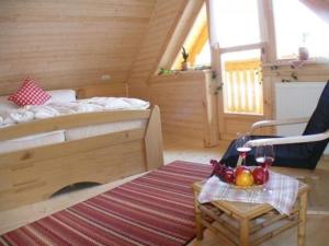 um quarto com uma cama e uma mesa com um copo de vinho em Urlaub im Bayerwaldblockhaus - Hütte im Bayerischen Wald in Philippsreut em Philippsreut