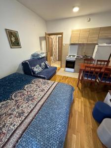 a bedroom with a bed and a kitchen with a table at Ania apartment in Podgorica