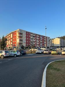 a parking lot with cars parked in front of a building at Ania apartment in Podgorica