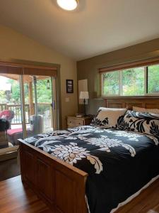 a bedroom with a bed with a black and white blanket at Cozy Corner Cottage in Port Renfrew