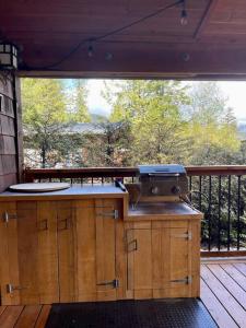 an outdoor kitchen with a grill on a deck at Cozy Corner Cottage in Port Renfrew