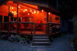 a house with a porch with lights on it at Cozy Corner Cottage in Port Renfrew