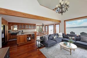 sala de estar con sofá, mesa y cocina en WhidbeyBeachHouse, an Oceanfront Getaway on a Private Beach, en Langley
