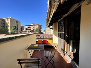 een balkon met een tafel en banken in een gebouw bij Grande appartamento in area storica di Bergamo in Bergamo