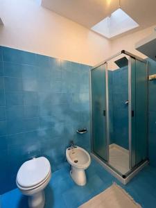 een blauwe badkamer met een toilet en een douche bij Grande appartamento in area storica di Bergamo in Bergamo