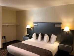 a hotel room with a large bed with white pillows at Casa Royal Inn in San Jose