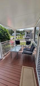 una veranda con sedie e un tavolo su una terrazza di Discover St Georges Basin a St Georges Basin