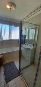 uma casa de banho com um chuveiro, um lavatório e um espelho. em Discover St Georges Basin em St Georges Basin