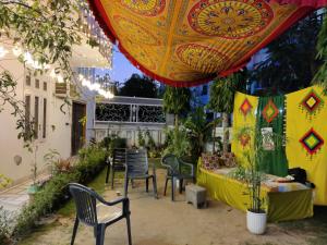 a patio with chairs and a table with a table cloth at House No 87A in Jaipur